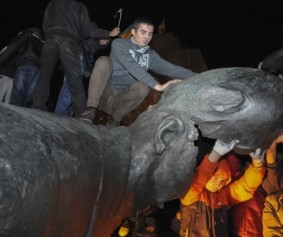 People react after a statue of Soviet state founder Vladimir Lenin was toppled by protesters during a rally organized by pro-Ukraine supporters in the centre of the eastern Ukrainian town of Kharkiv